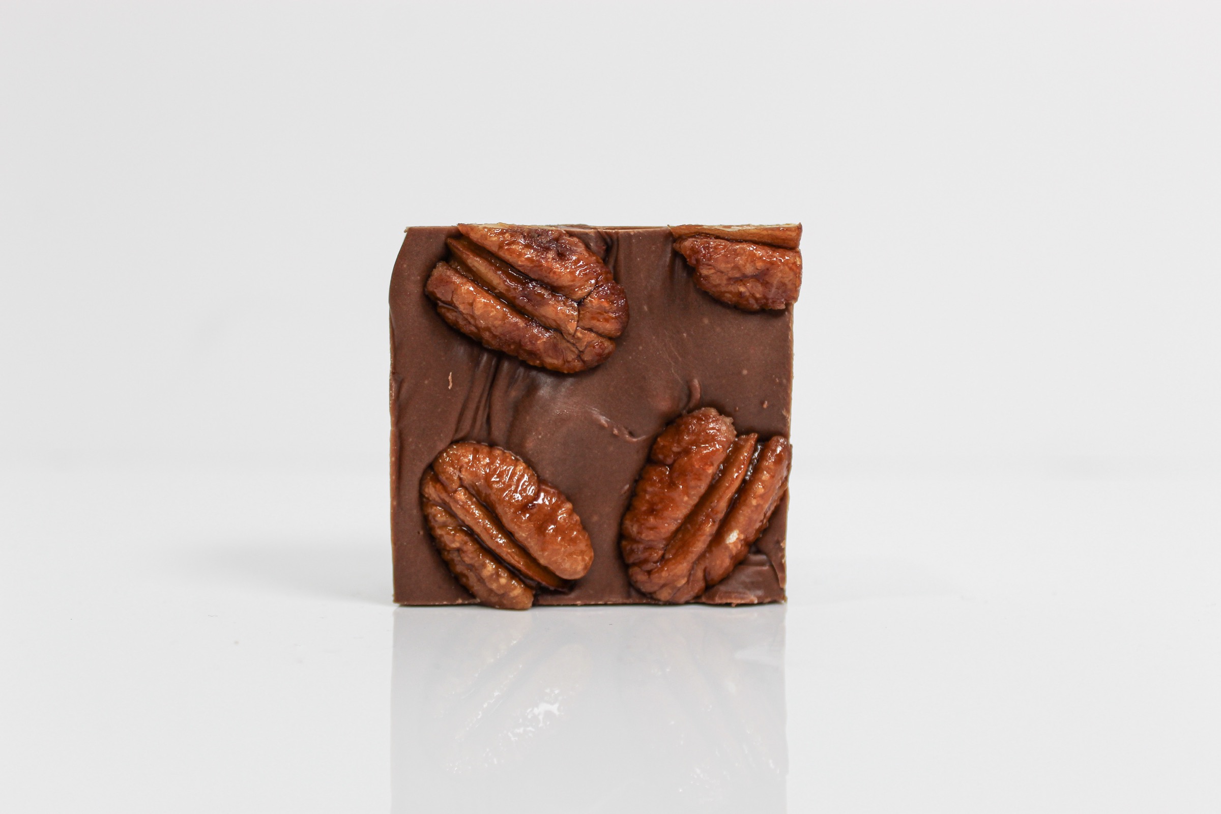 A single square of Hill Country Chocolate pecan fudge topped with long-roasted pecan halves